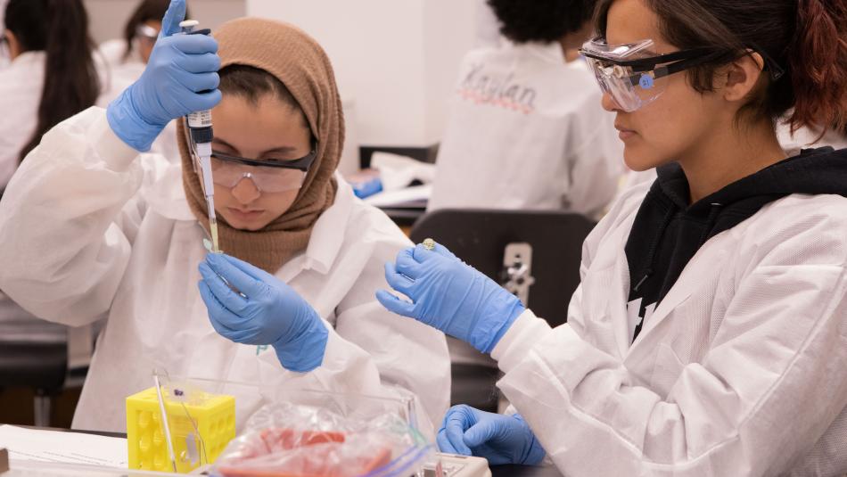 Students wearing lab coats working in a lab