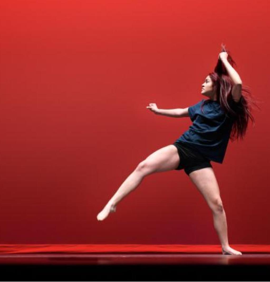 A woman dancing against a red background