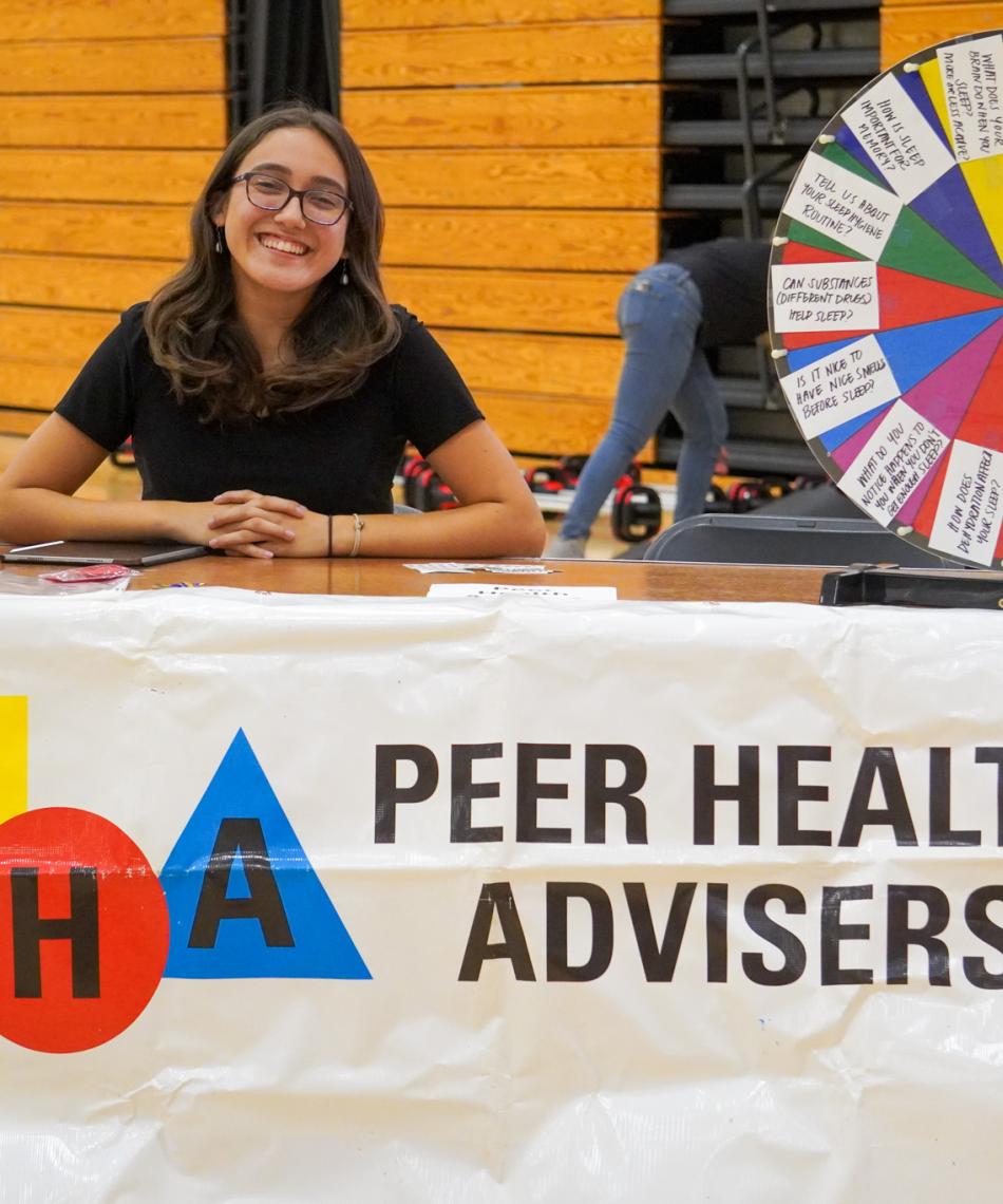 A peer health adviser at a student fair