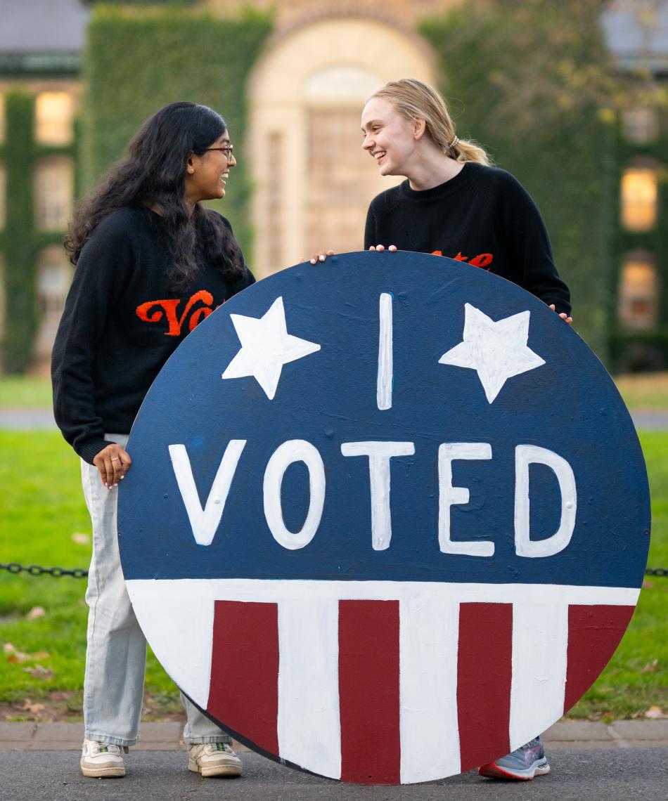 Two students holding an "I voted" sign