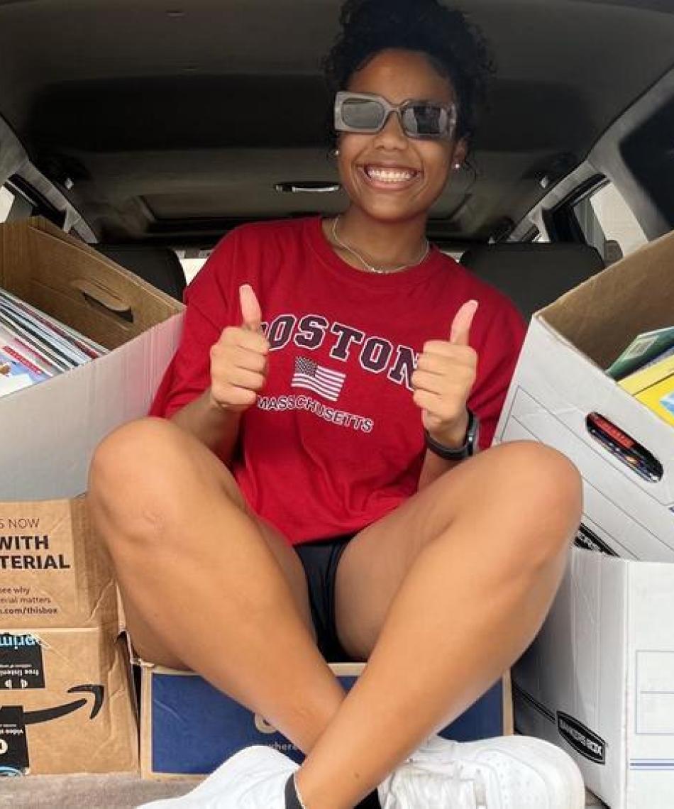 Student posing with boxes 