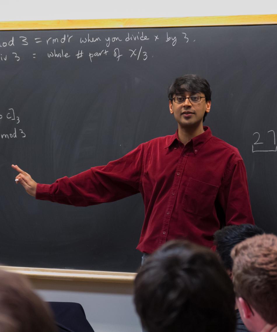 Teacher standing in front of a chalkboard 