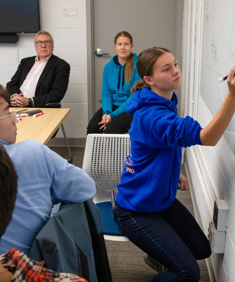 Student writing on board 