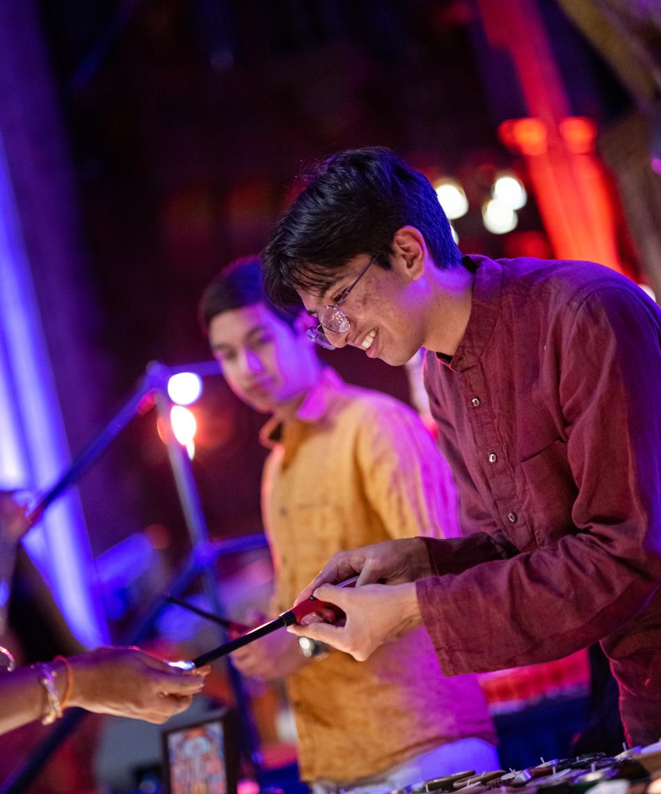 Student lighting a candle for Diwali
