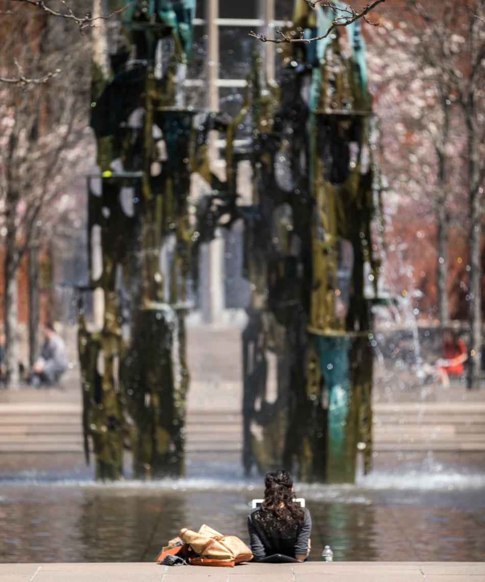 Student relaxing by a fountain