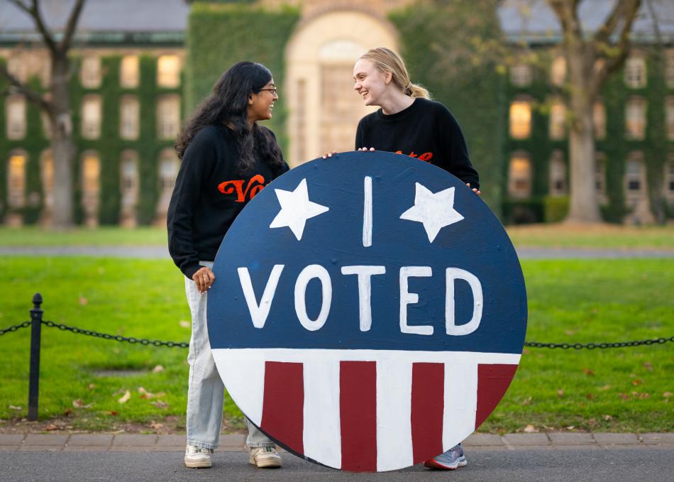 Two students holding an "I voted" sign