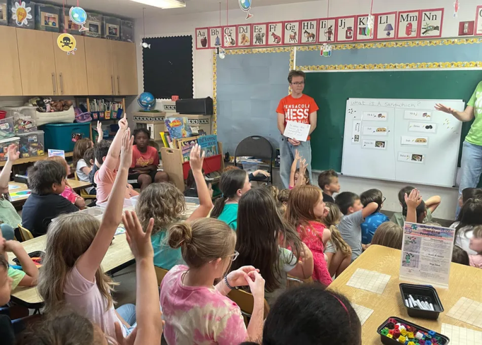 A student in a classroom volunteering