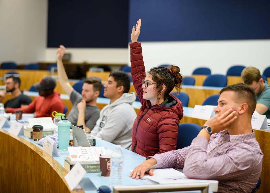 Student raising hand in classroom
