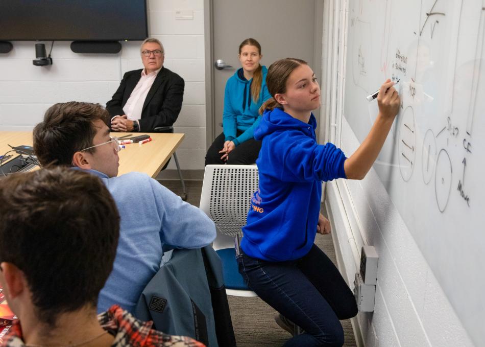 Student writing on board 