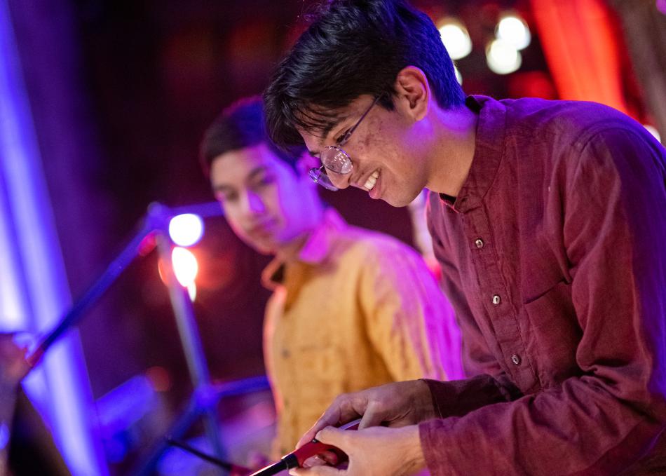 Student lighting a candle for Diwali